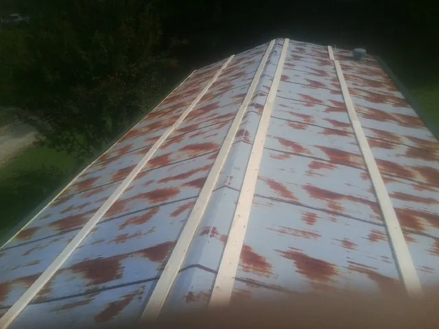 Rusted metal roof panels with new wood purlins before replacement — Storm Damage Roof Repair in College Springs by Roofing Brothers