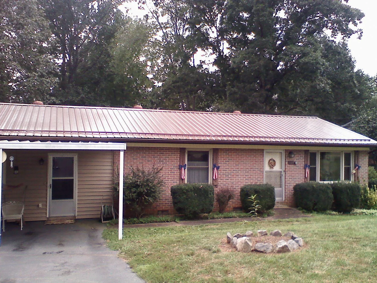 Bronze metal roof and carport on a brick ranch home — Roof Repair work by our crew in College Springs